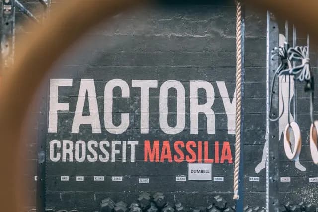 Mur « Factory – CrossFit Massilia » vu à travers un anneau de gymnastique