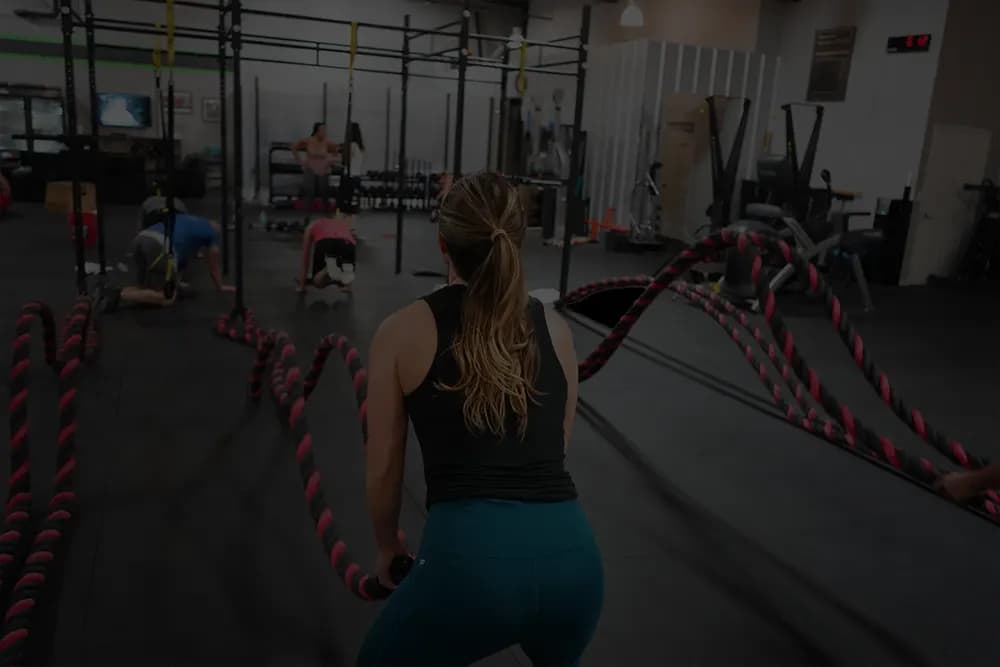 Athlète aux battle ropes pendant un WOD